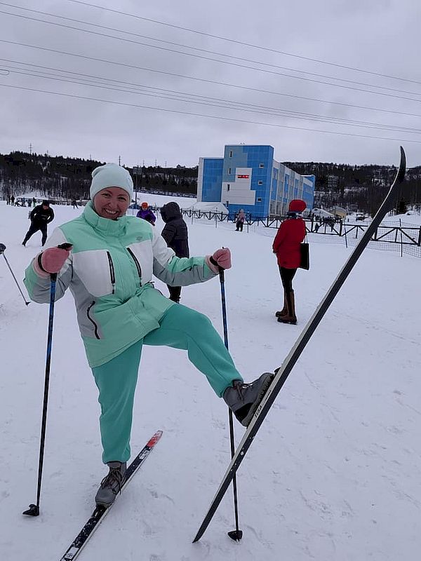 Председатель Мурманского РО ВОС Т. А. Губайдуллина на лыжах. Она стоит на одной лыже, а вторую подняла вверх.