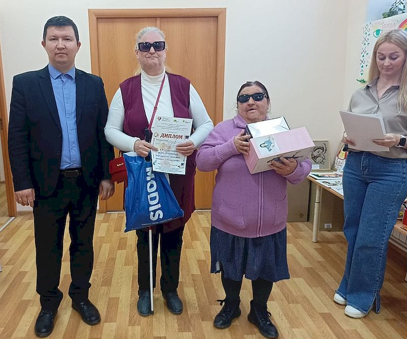 Председатель Марийской РО ВОС С. А. Замков с участниками выставки. Участники держат в руках дипломы.