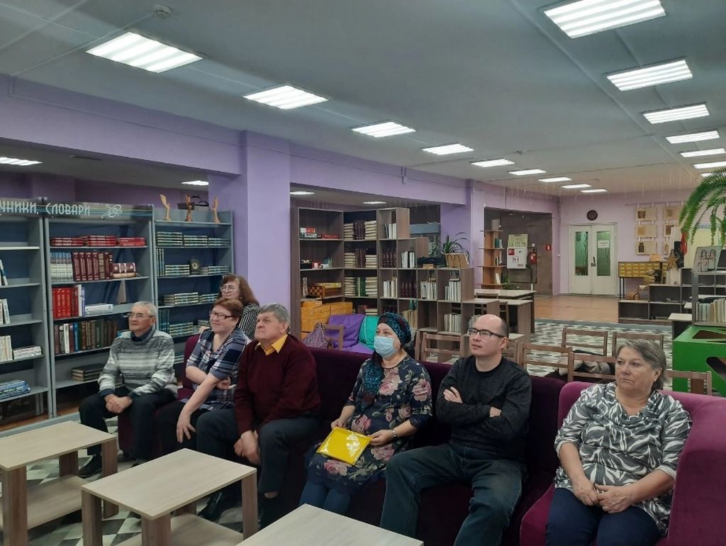 Участники игры внимательно слушают вопросы ведущих в библиотеке для слепых