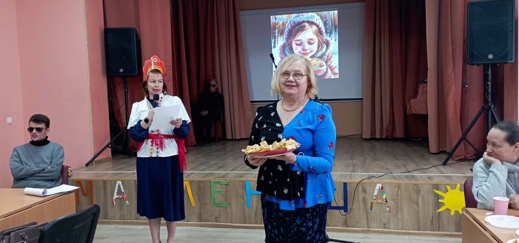 В центре зала - женщина с блинами