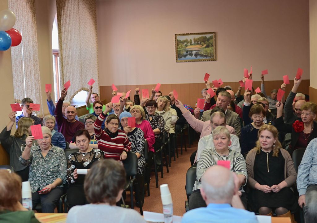 Люди в зале голосуют мандатами