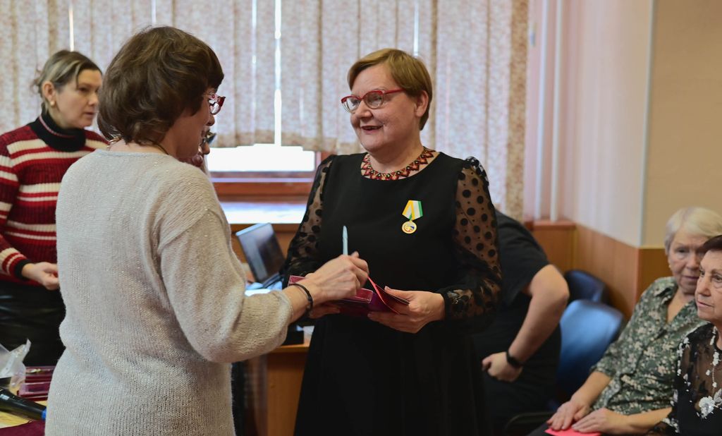 Ирина Анатольевна вручает награду женщине 