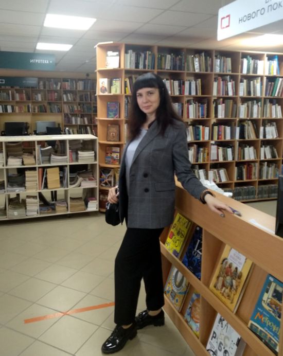 Массальская Марина Александровна в полный рост в библиотечном зале