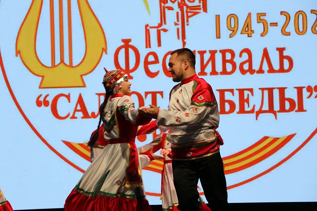 на сцене танкует пара в народных костюмах