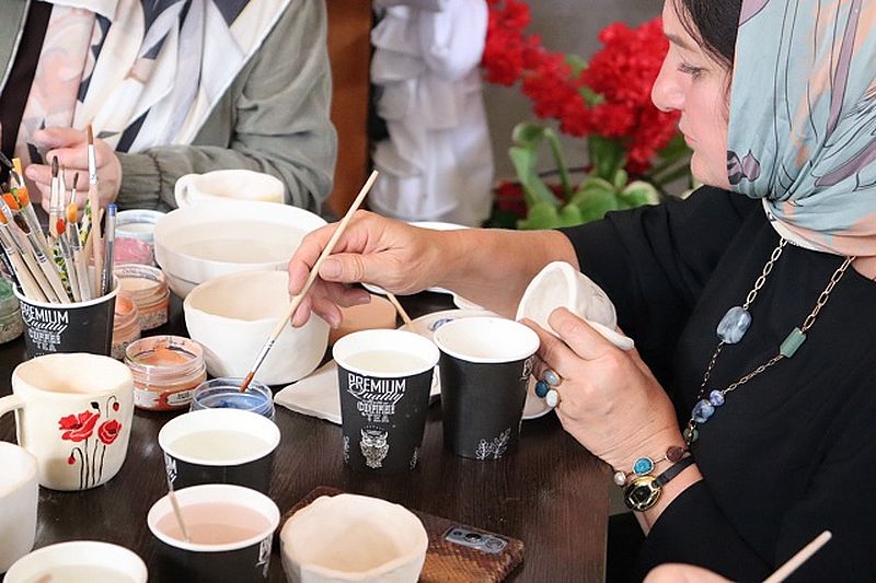 участники мероприятия расписывают керамические изделия