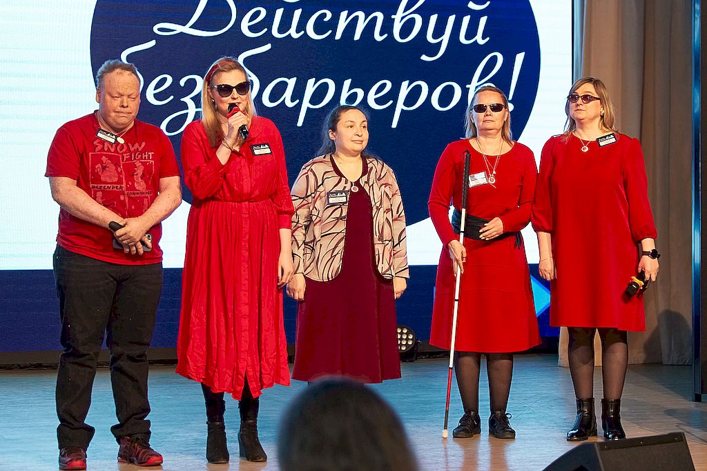 Команда "Малинки". Четверо девушек и один мужчина стоят на сцене. Они одеты в одежду разного оттенка красного цвета.