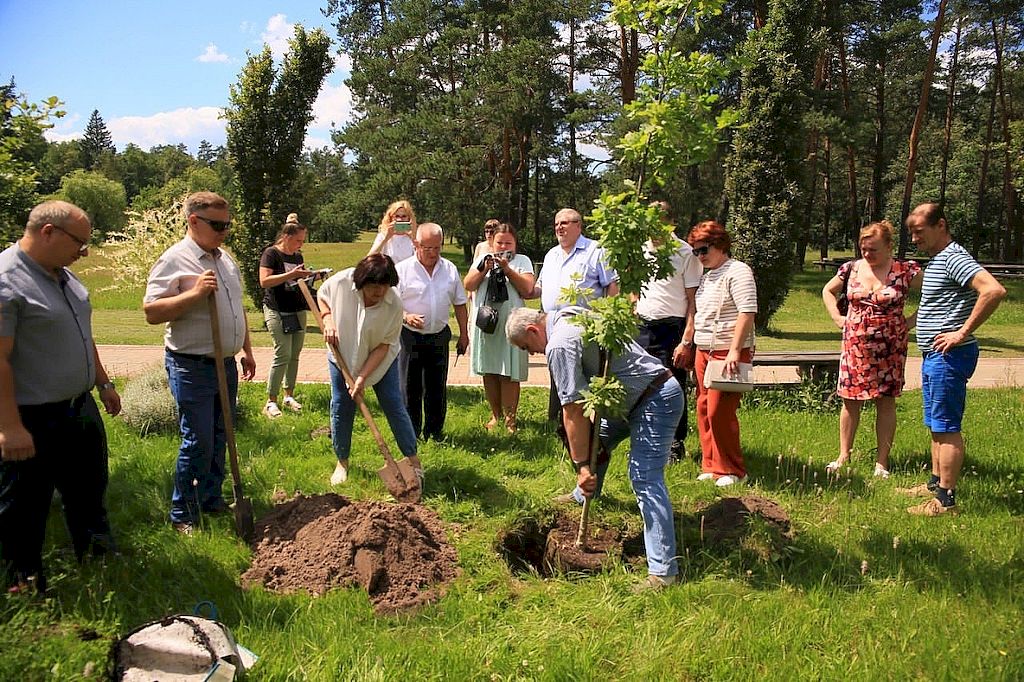 Представители делегаций ВОС высаживают дерево.