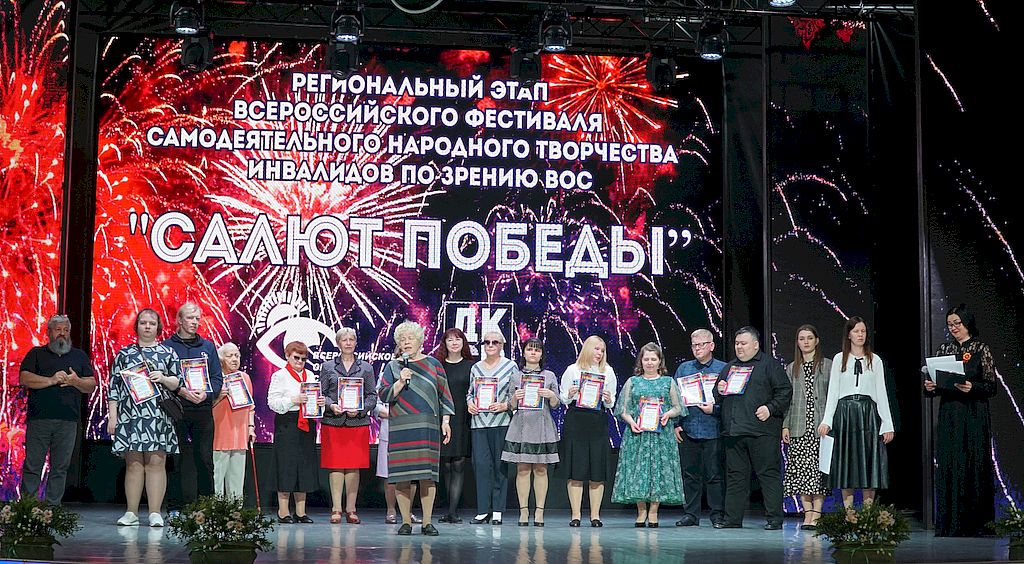 Общая фотография участников и организаторов Фестиваля на сцене с дипломами. На большом экране название фестиваля.