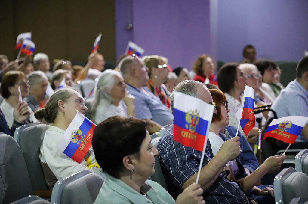 зрители в зале с флагами России