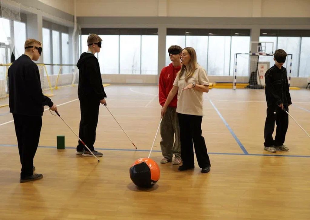 в спортивном зале люди с повязками на глазах и тростями