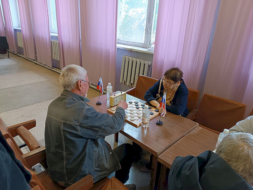 Мужчина и женщина играют в шашки