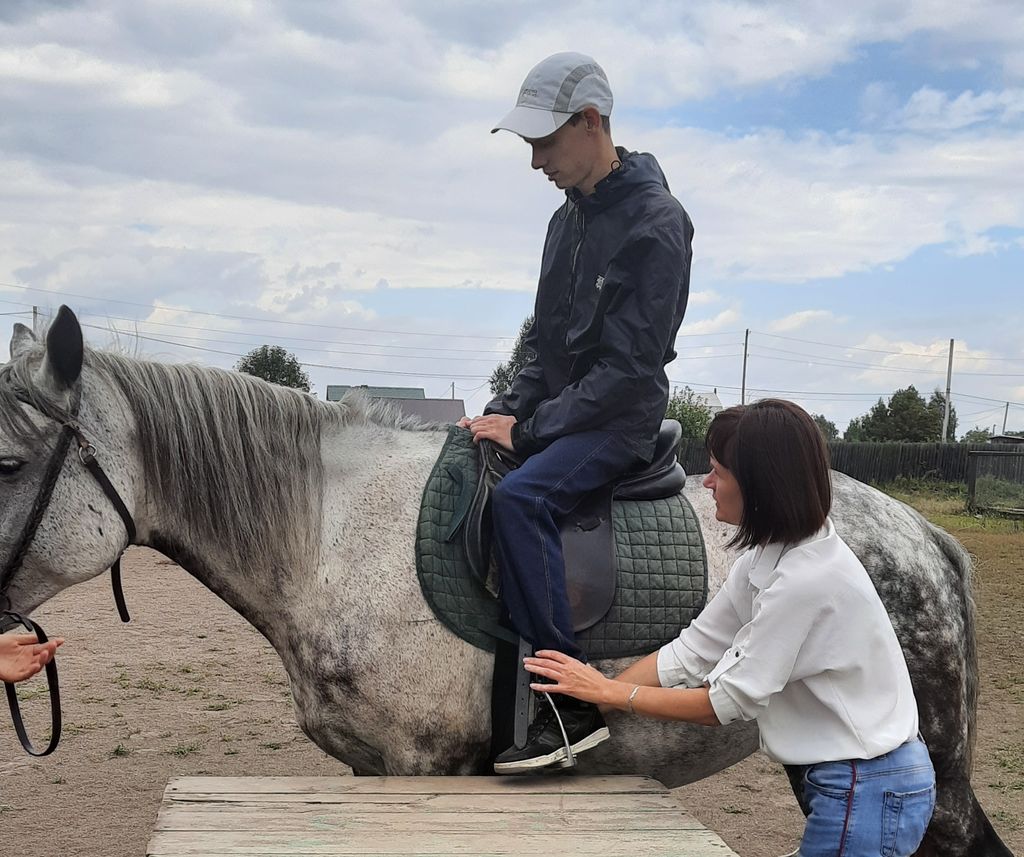 Обучение инвалида по зрению правильной посадке на лошадь