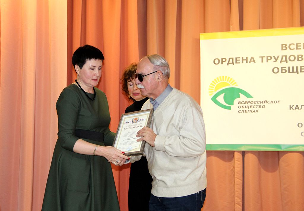заместитель министра социальной политики региона Е. Н. Павлова вручает награды на сцене.