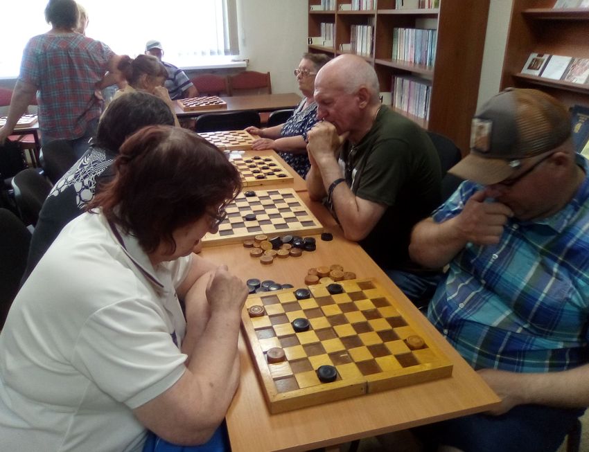 в кадре шесть игровых досок, за которыми играют взрослые члены вос