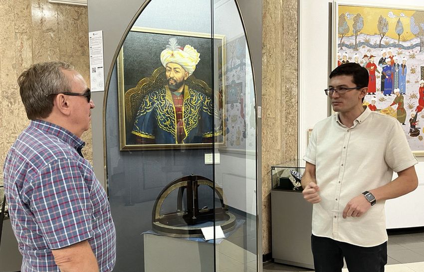 Музей. На фото В. В. Сипкин и молодой мужчина-экскурсовод рядом с витриной, за которой расположен портрет Амира Тимура.