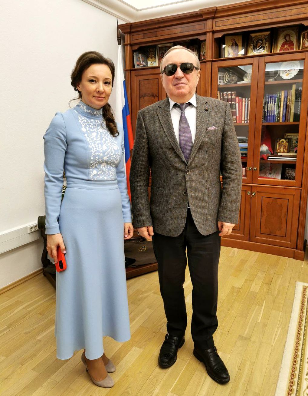 В рабочем кабинете стоят Анна Юрьевна Кузнецова и Владимир Васильевич Сипкин. На заднем плане стенка с книгами и православными иконами.