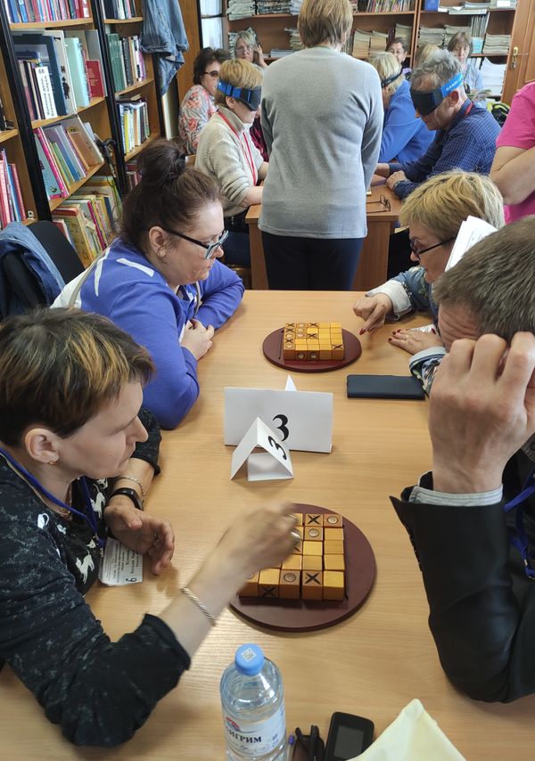 Инвалиды по зрению играют в настольные игры для слепых