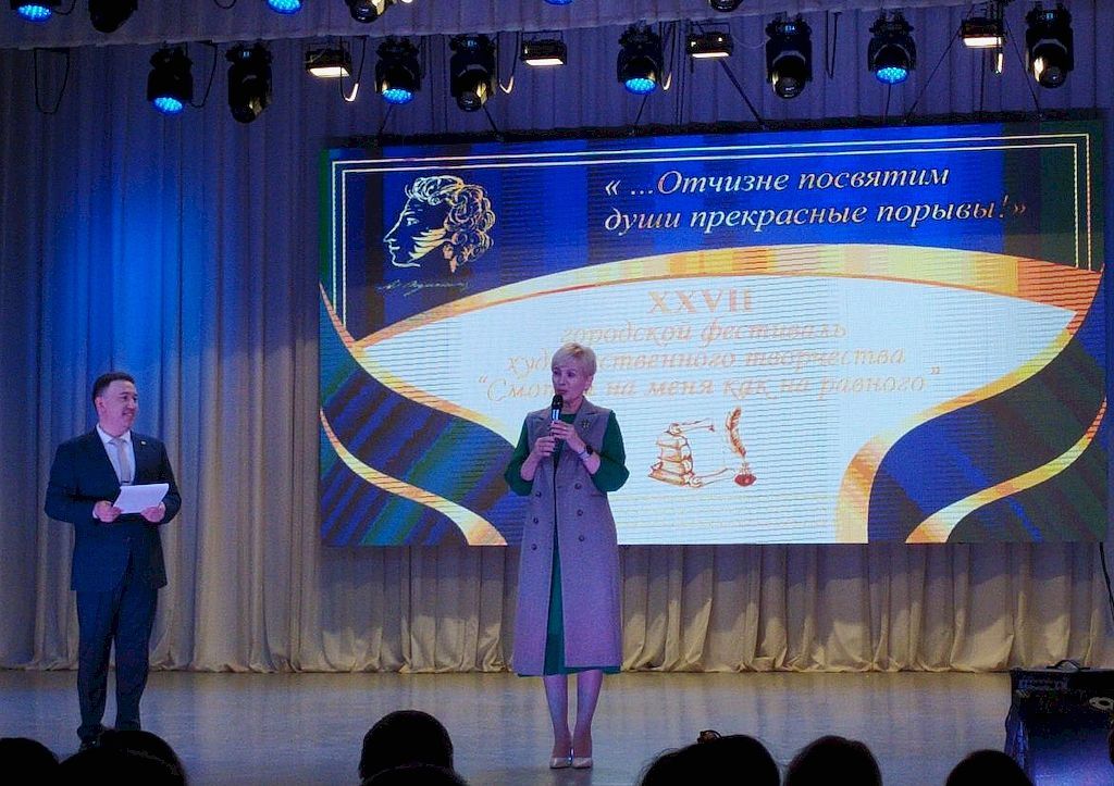 Ведущий и почётный гость на открытии фестиваля. Они стоят на сцене.