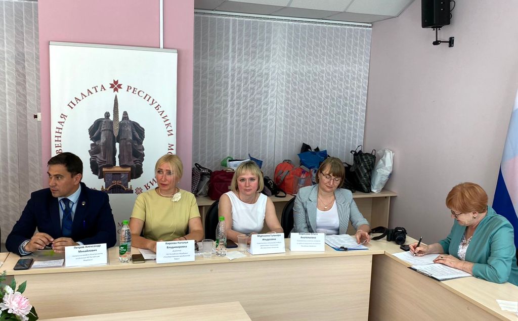 Приглашённые эксперты за рабочим столом с именными табличками. Справа за столом М. И. Пуряева.