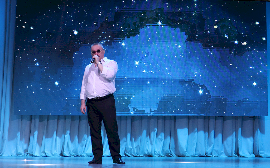 на сцене Истомин Максим. Мужчина в тёмных брюках и белой рубашке