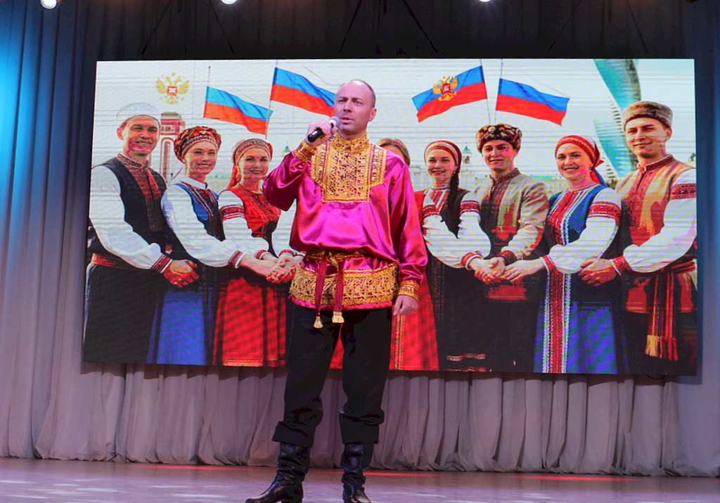 на сцене Крылышкин Сергей. Мужчина в тёмных брюках и нарядной рубашке