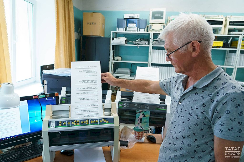 сотрудник библиотеки показывает, как делается бюллетень для слабовидящих