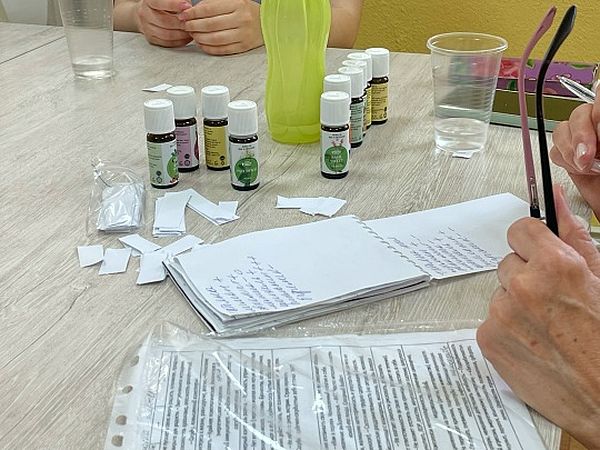 на столе стоят различные ароматы, лежит блокнот с записями