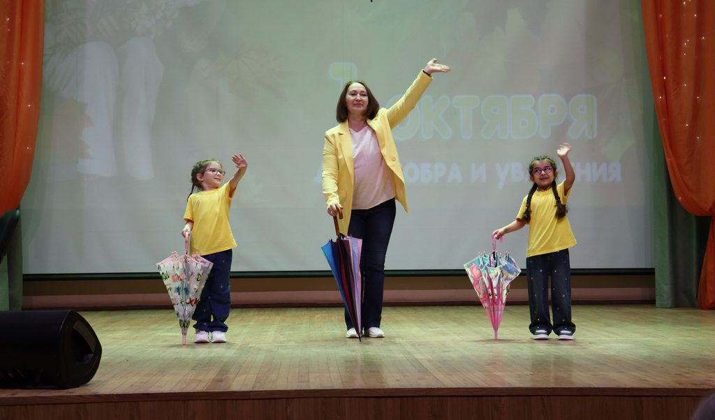 На сцене - 2 маленькие девочки и женщина с зонгиками
