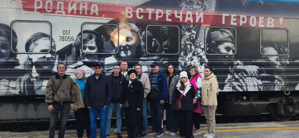 Участники экскурсии на фоне поезда Победы