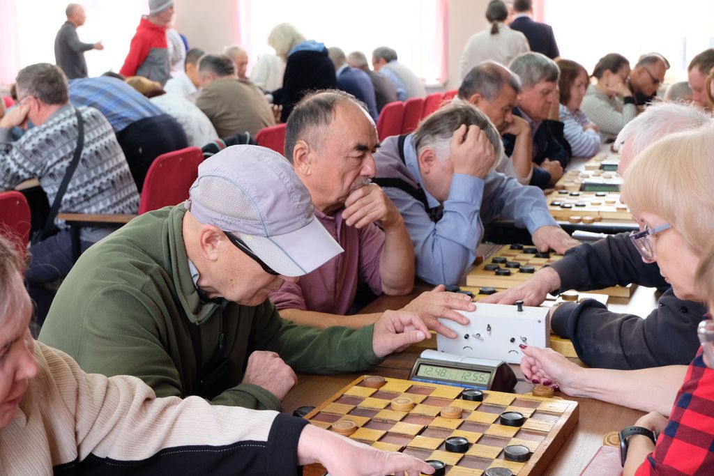 Участники чемпионата играют в шашки