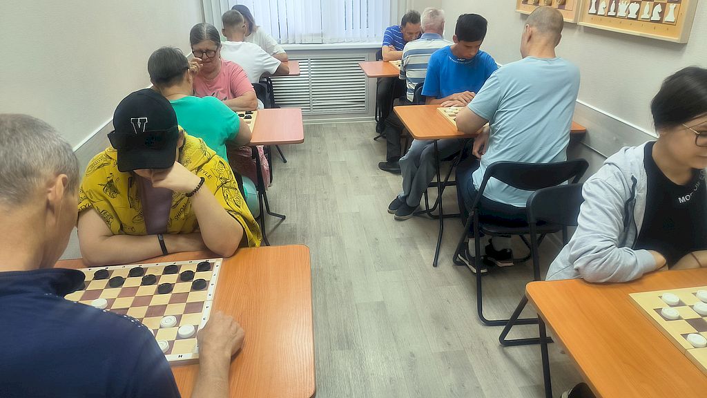 Участники соревнований сидят за игровыми досками